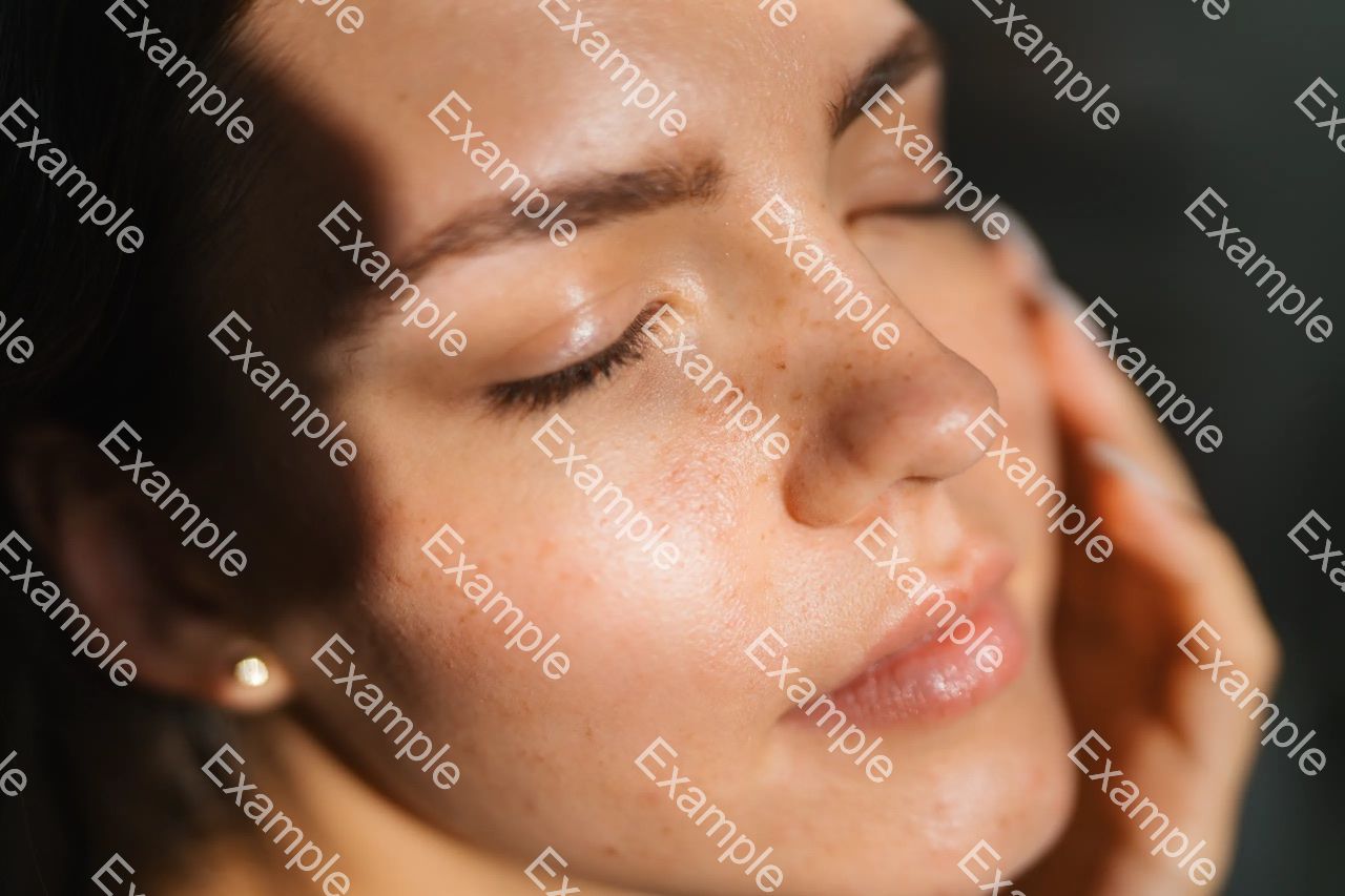 Close-up face covered by tiled Example watermarks for fine-detail inspection